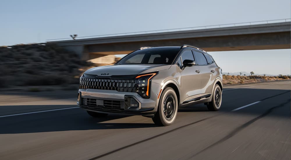 A gray 2026 Kia Sportage driving down a highway