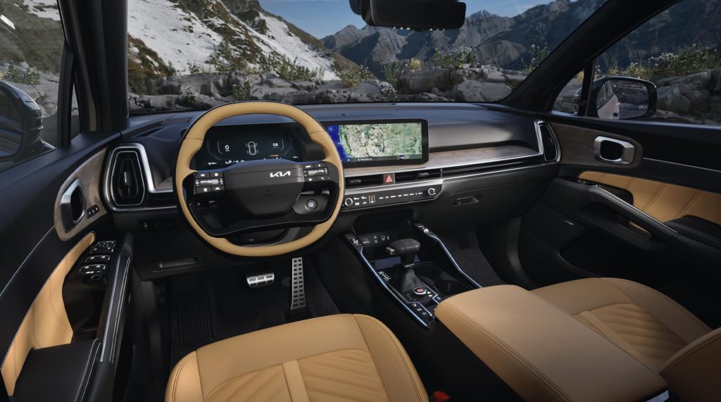 The black and tan interior of a 2026 Kia Sorento, including the steering wheel and dashboard.