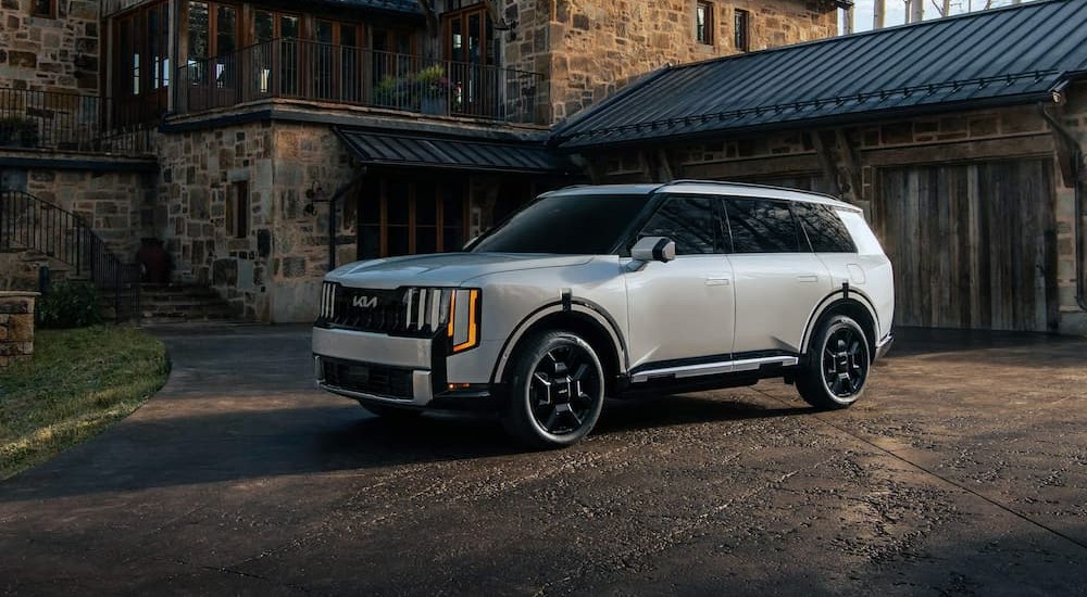 A silver 2027 Kia Telluride parked near a house.