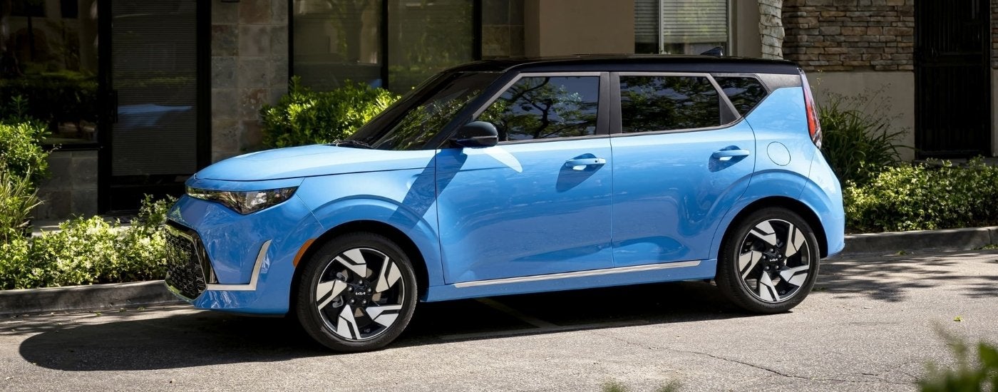 Blue 2024 Kia Soul parked in front of a building