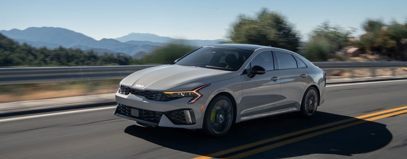 A silver-grey 2025 Kia Forte GT-Line driving on the highway.