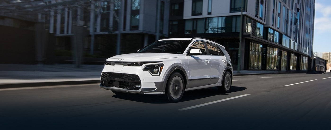 White 2025 Kia Niro EV driving to a Kia dealer near Roselle