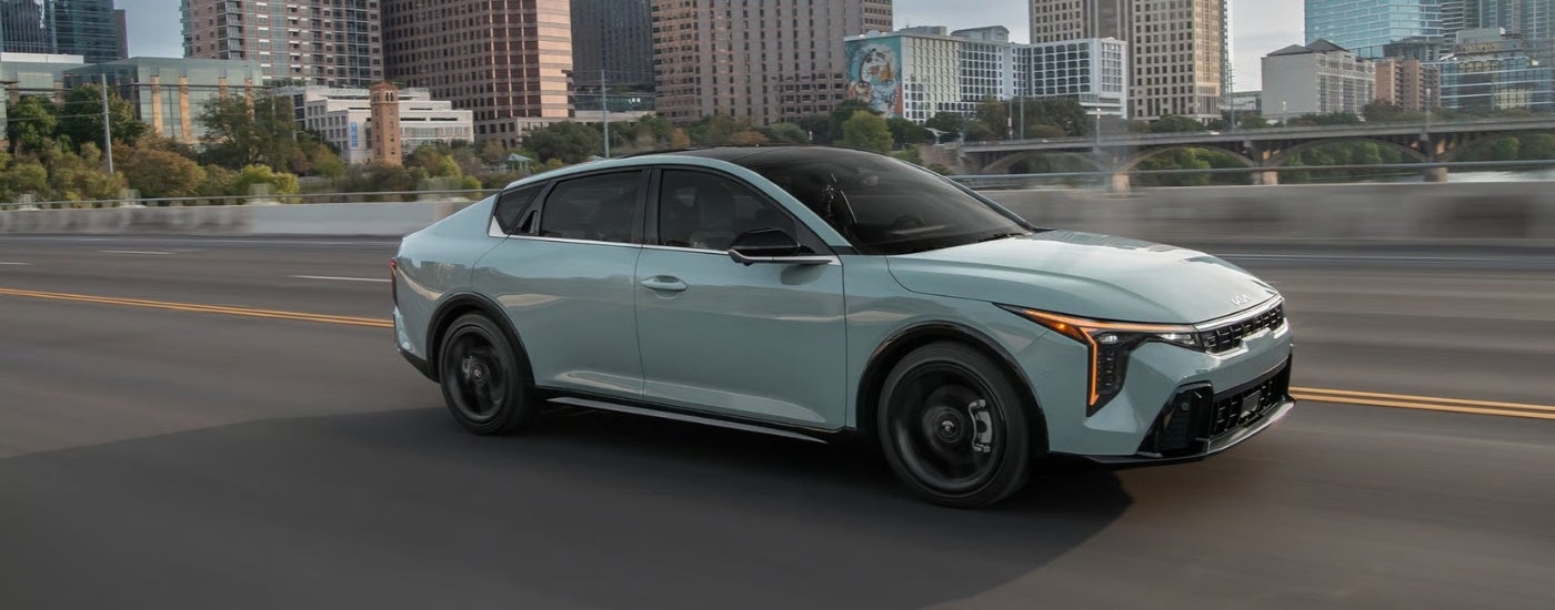 Green 2026 Kia K4 driving to a Kia dealer near Barrington
