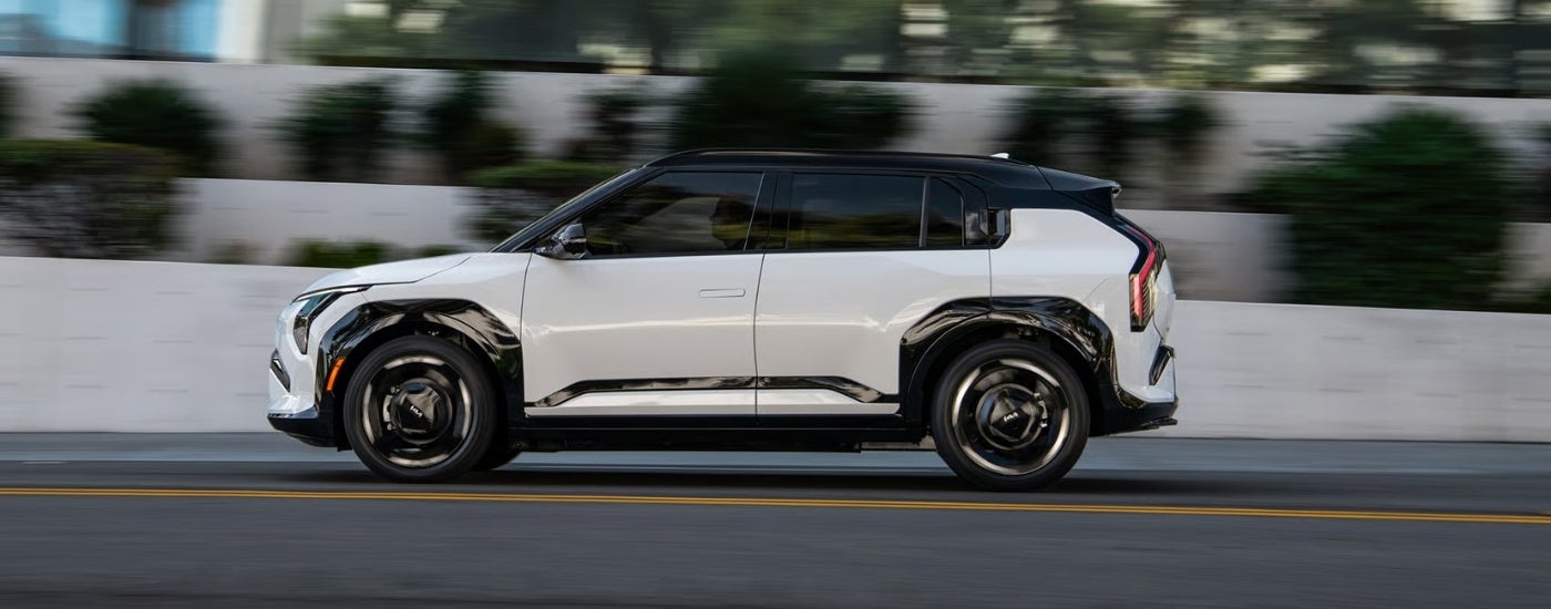 White 2027 Kia EV3 driving to a Kia dealer near Wauconda