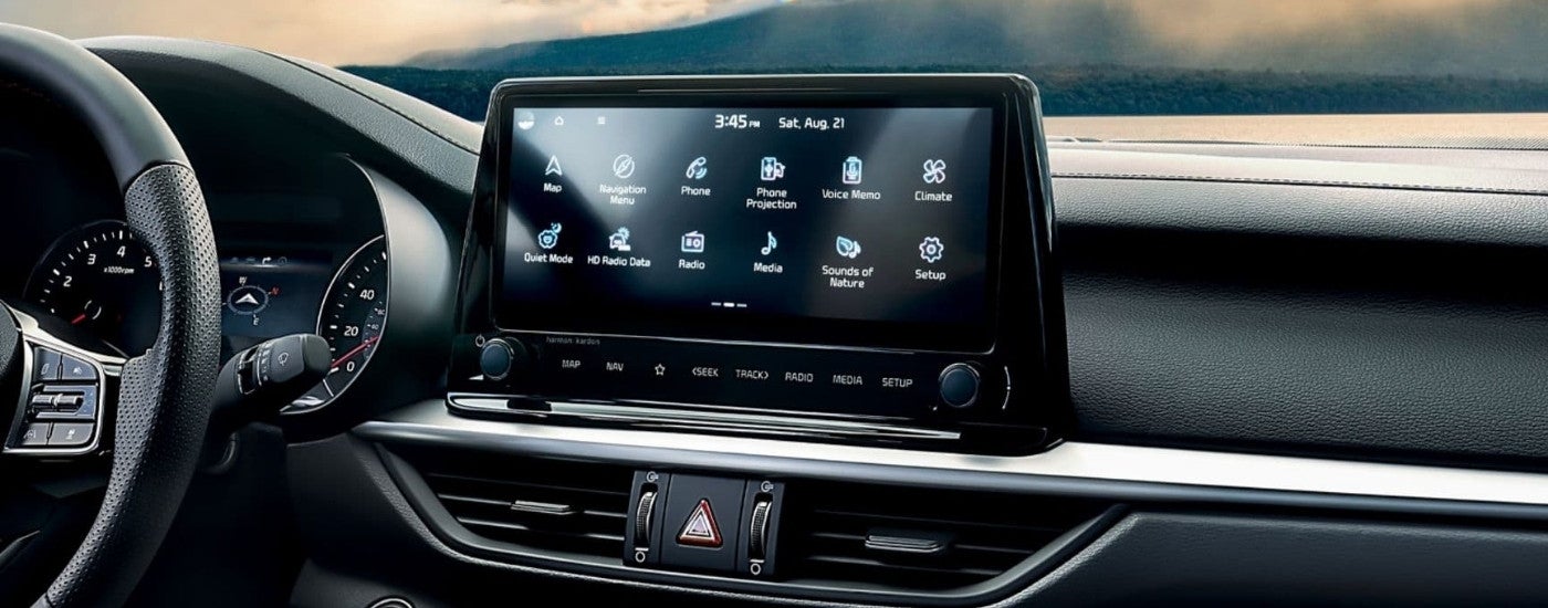 A close-up shows the infotainment screen in a 2024 Kia Forte.