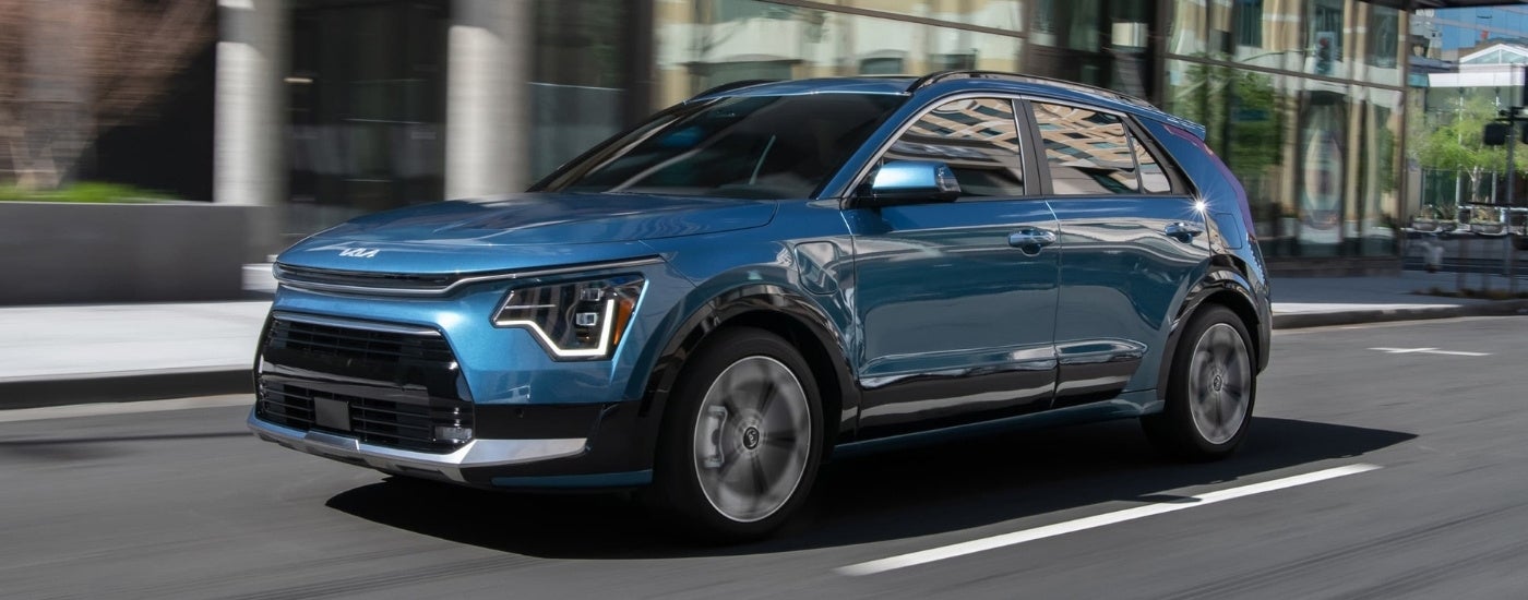 A blue 2024 Kia Niro PHEV is shown driving to a Kia dealer near Chicago.
